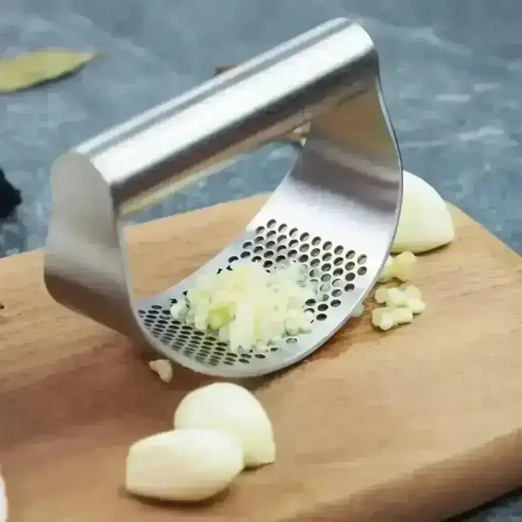 Stainless Steel Garlic Press - Garlic Crusher on a cuting board with garlic.